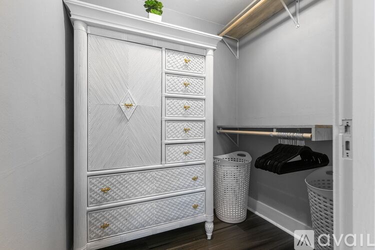 A white cabinet with drawers and a plant on top.
