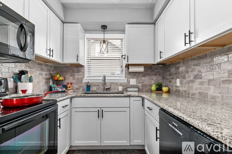 A kitchen with white cabinets and a black stove top oven.