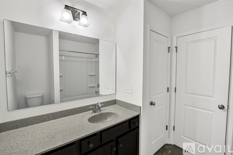 A bathroom with a sink, mirror, and two doors.