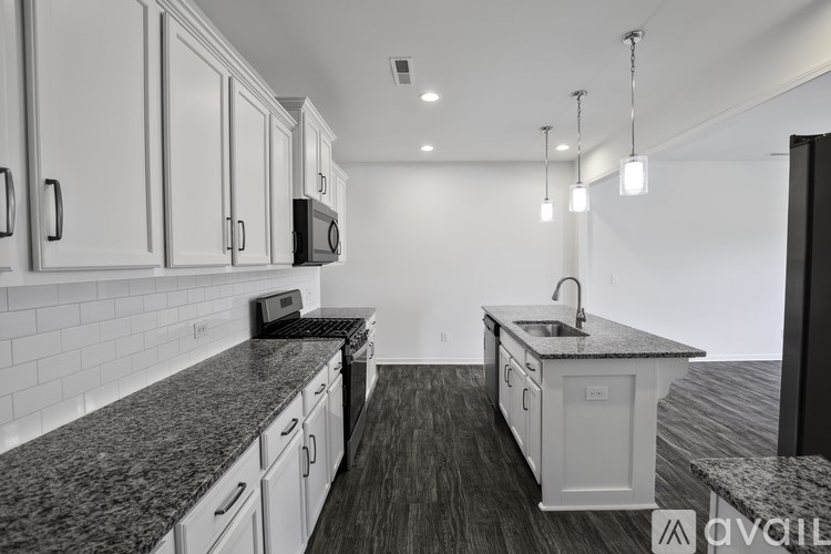 A kitchen with granite countertops and white cabinets.
