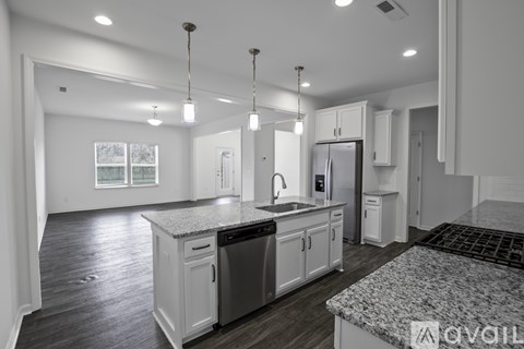 A kitchen with white cabinets and a granite countertop.