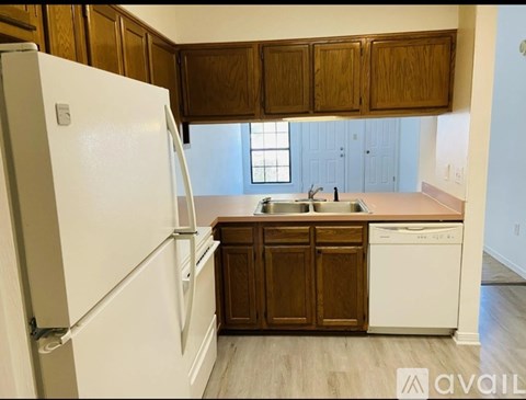 A kitchen with a white refrigerator and wooden cabinets.