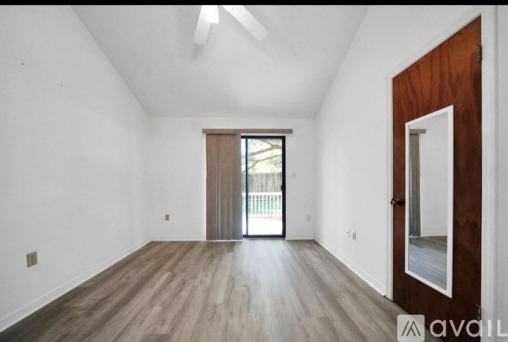 A room with wooden floors and a sliding glass door.