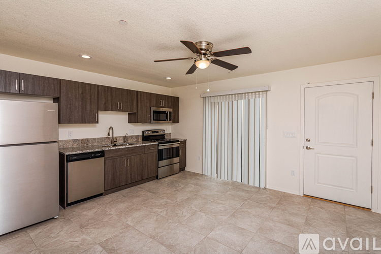 A kitchen with a refrigerator, sink, and stove.