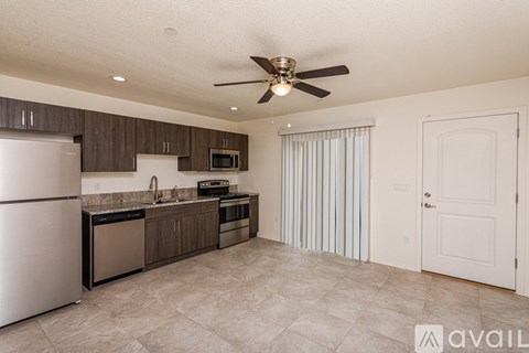 A kitchen with a refrigerator, sink, and stove.