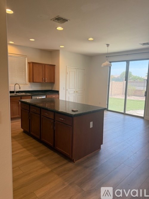 A kitchen with wooden cabinets and a black countertop.