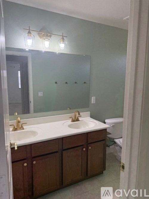 A bathroom with two sinks and a large mirror.