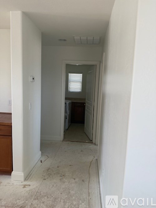 A hallway with a door on the right and a counter on the left.