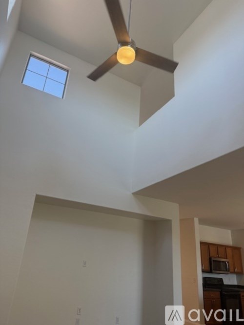 A ceiling fan hangs from the ceiling in a room with a window.