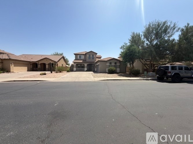 A sunny day in a residential area with houses and a parked car.