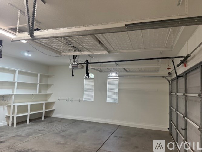 A large empty room with a white ceiling and walls, and a concrete floor.