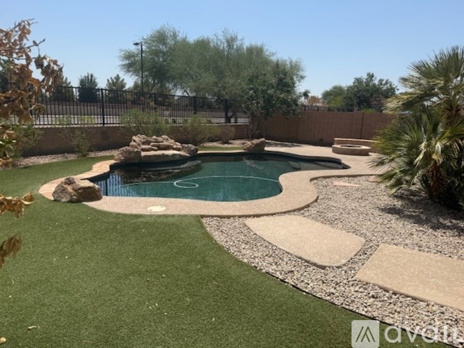 A small pool surrounded by rocks and a gravel path.