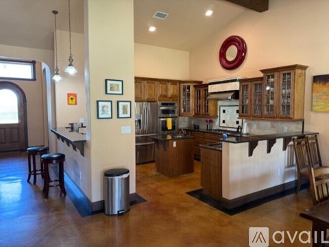 A kitchen with wooden cabinets and a bar area.