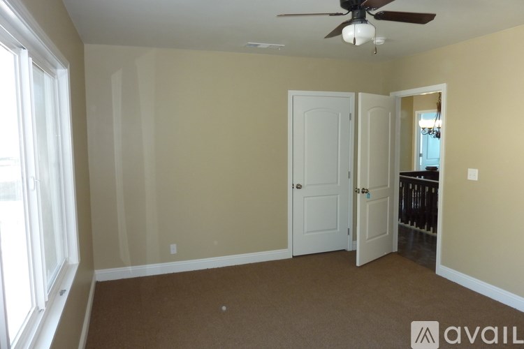 A room with a fan, two doors, and a window.