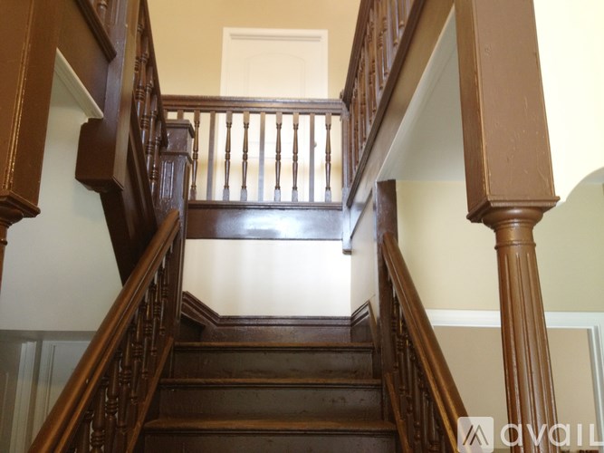 A wooden staircase with a white door at the top.