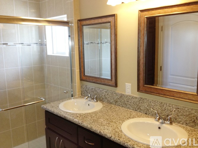 A bathroom with two sinks and a large mirror.