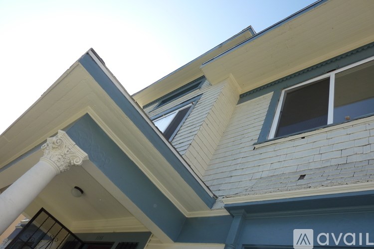 A house with a blue and white exterior and a white column.