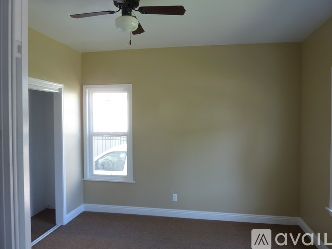 A room with a ceiling fan and a window.