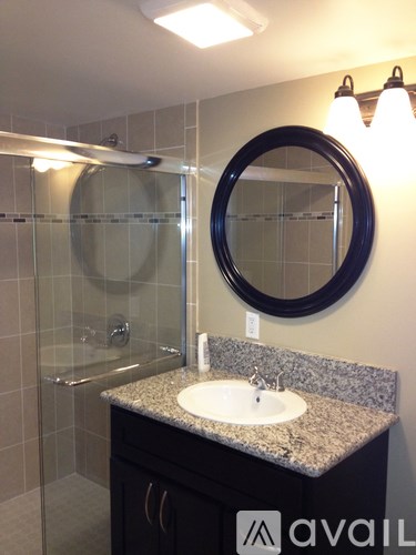 A bathroom with a sink, mirror and shower.