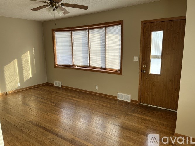 A room with wooden floors and a ceiling fan.