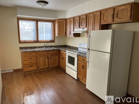 A kitchen with wooden cabinets and a white refrigerator.