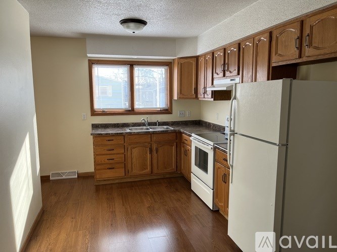 A kitchen with wooden cabinets and a white refrigerator.