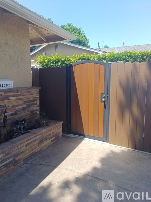 A brown gate with a wooden door is closed.