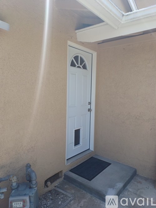 A white door with a glass window is set in a beige wall.
