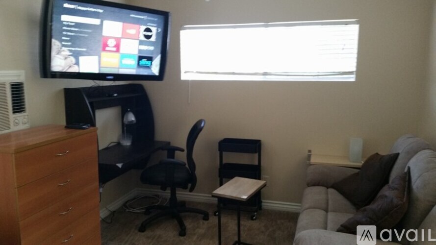 A living room with a television, a chair, and a couch.