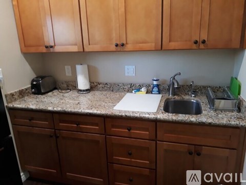 A kitchen with brown cabinets and granite countertops.