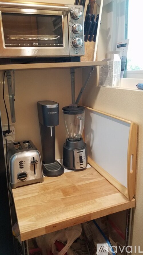 A kitchen counter with a toaster, blender, and oven.