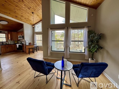 A living room with a table and two chairs.