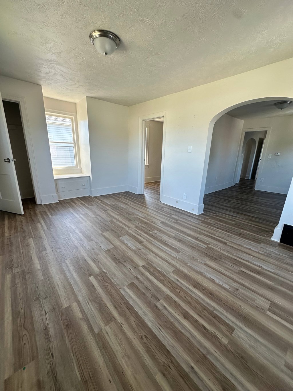 A room with wooden flooring and white walls.