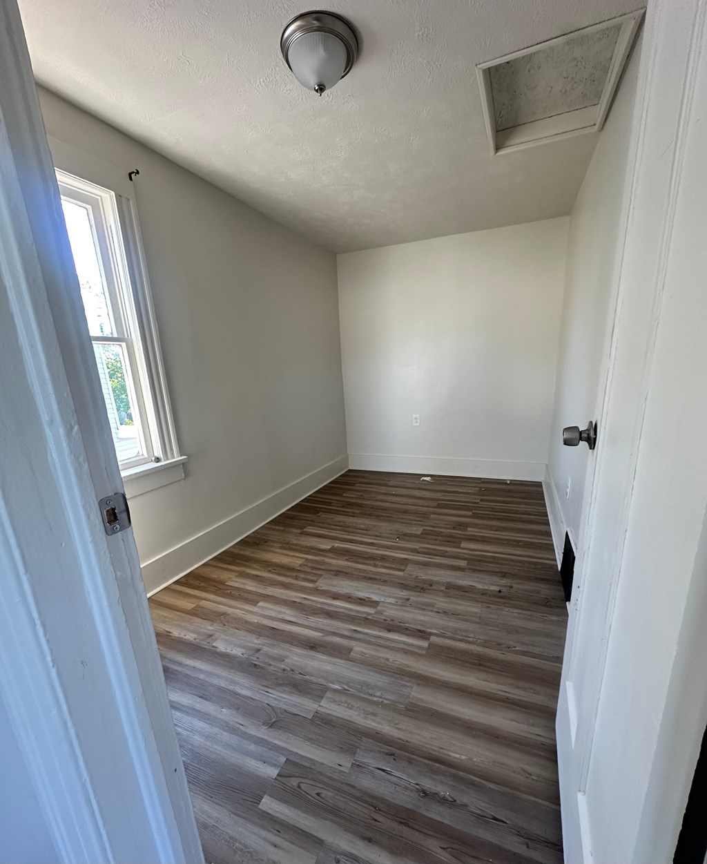 A room with a wooden floor and white walls.