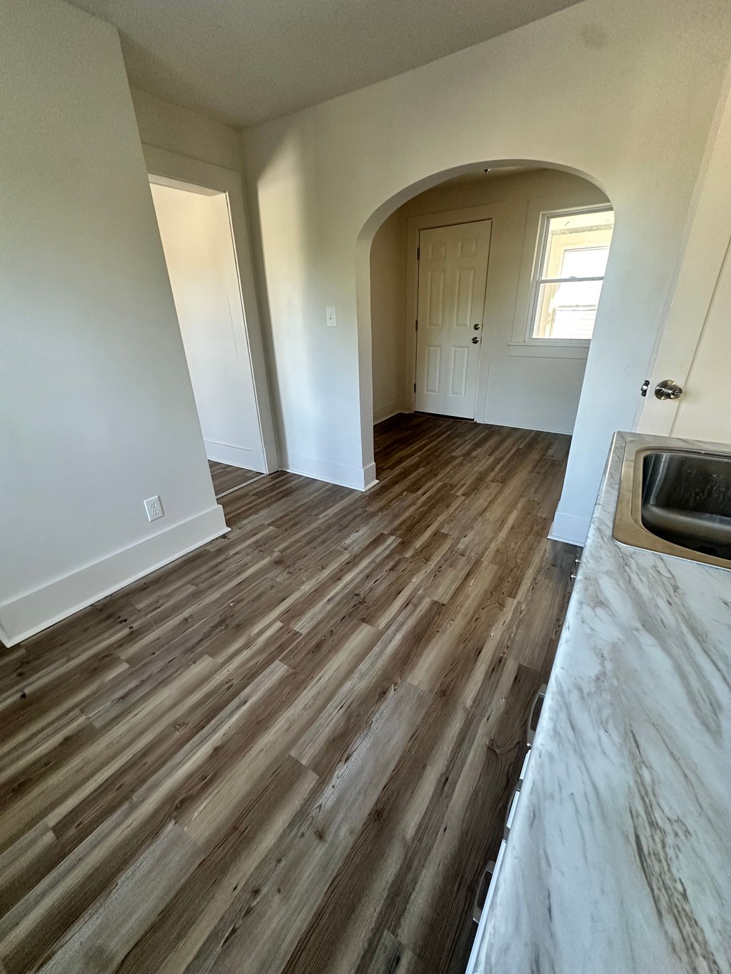 A room with wooden flooring and a fireplace.