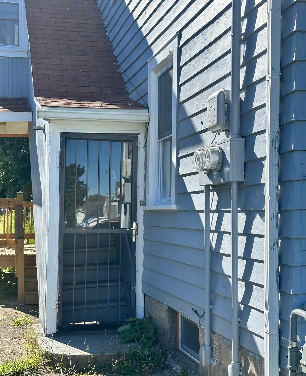 A house with a grey siding and a brown roof.
