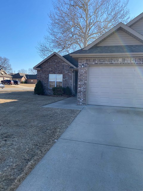A house with a garage door and a driveway.