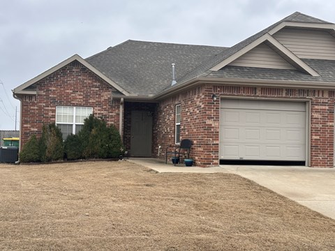 A brick house with a grey garage door.
