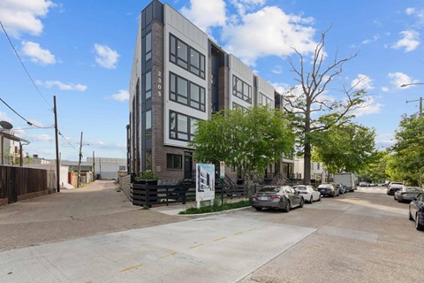 A modern building with a parking lot in front.