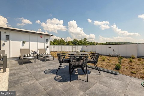 A patio with a table and chairs is set up on a rooftop.