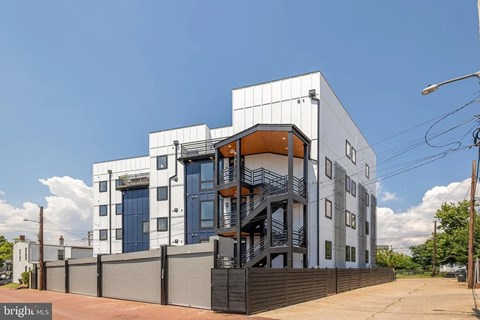 A modern building with a white facade and a blue door.