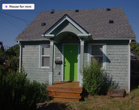 A small house with a green door is for rent.