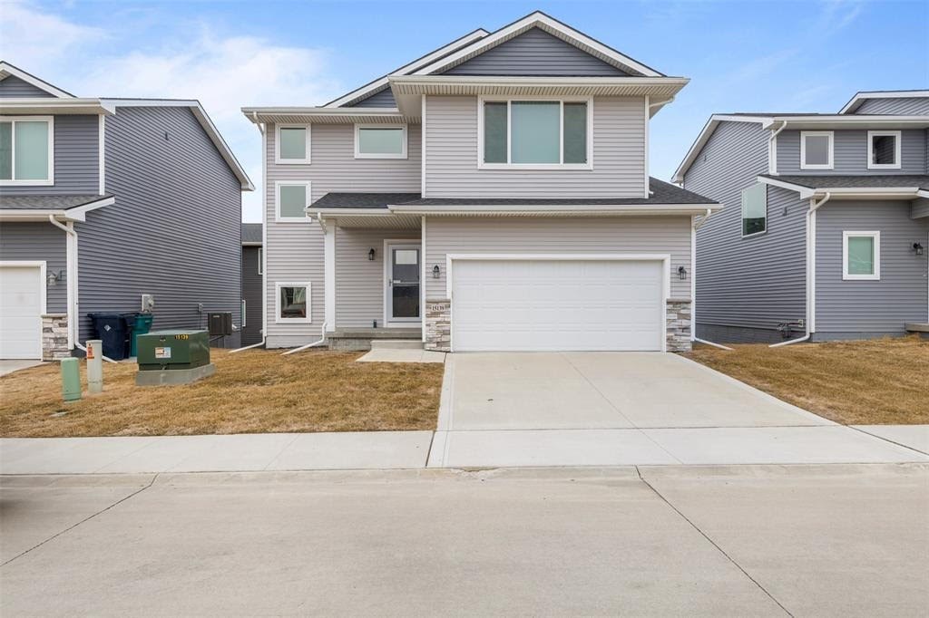 A grey house with a white garage door in front.