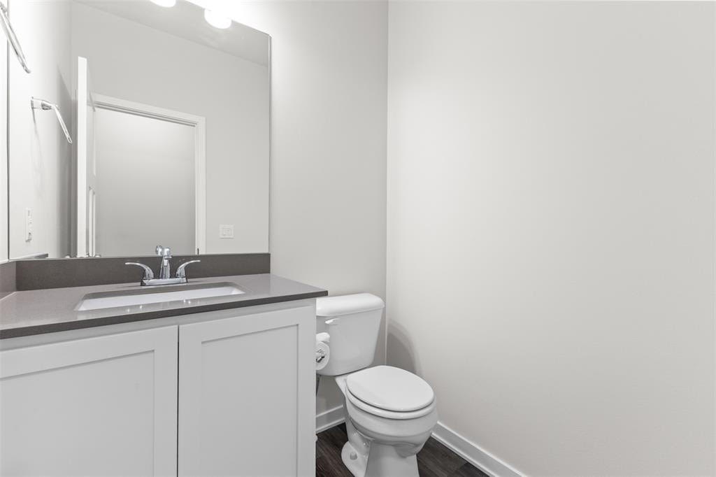 A white toilet sits next to a sink in a bathroom.