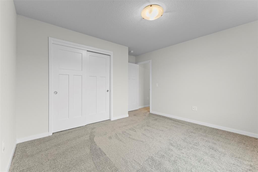 A room with a carpeted floor and a white door.