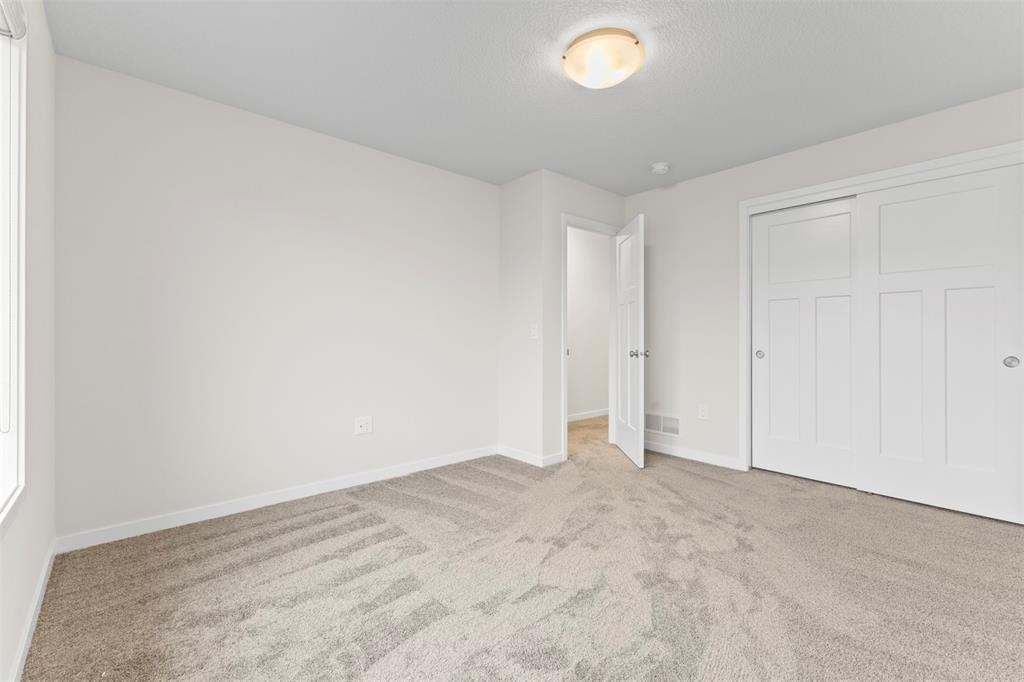A room with a carpeted floor and a white door.