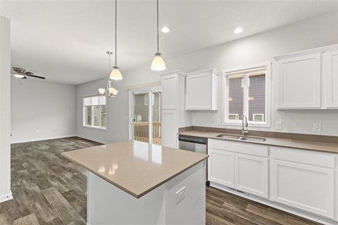 A kitchen with white cabinets and a wooden island.
