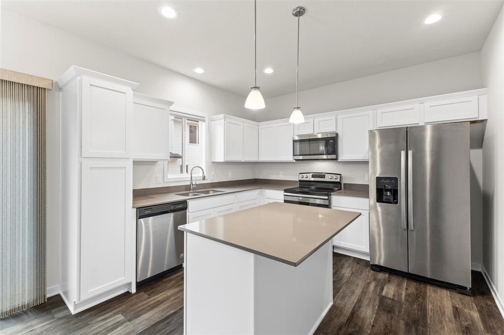 A modern kitchen with white cabinets and stainless steel appliances.