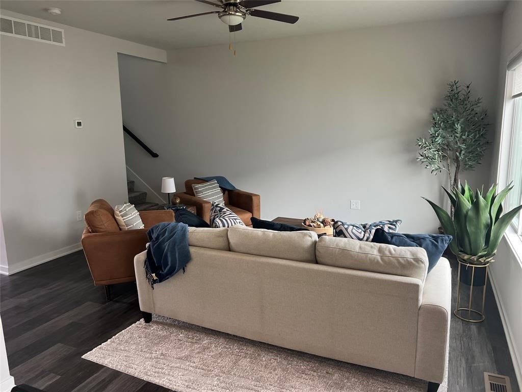 A person is lying on a beige couch with a blue blanket.