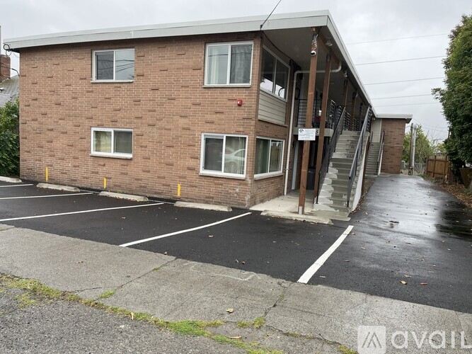A brick building with a parking lot in front.